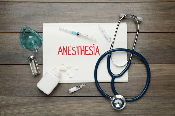 Tahta masada anestezi ve uyuşturucu içeren düz bir kompozisyon.