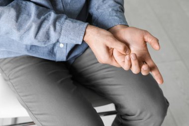 Kapalı mekanda parmak tetiğinden muzdarip bir adam.