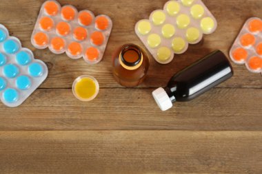 Öksürük şurubuyla tahta masa üzerinde düz bileşim, metin için boşluk