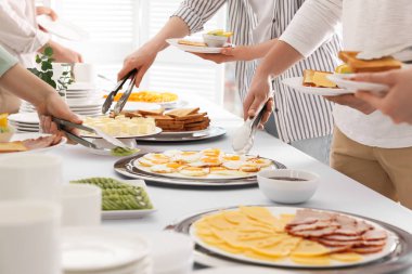 Kahvaltıda yemek yiyen insanlar, yakın çekim. Büfe servisi