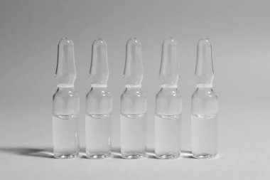 Açık gri arka planda ilaçlı ilaç ampulleri