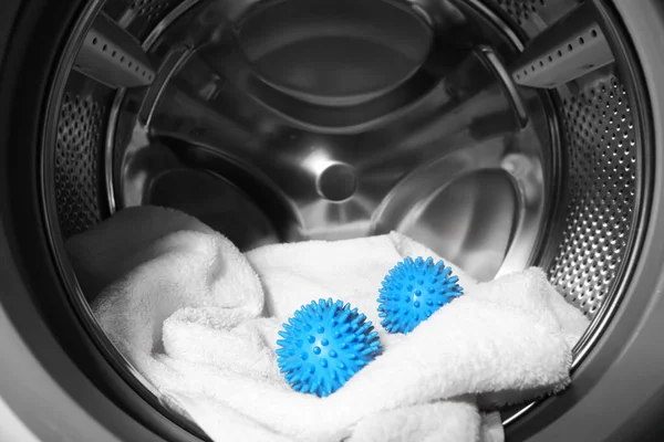 洗濯機のドラムで青いドライヤーボールとタオル クローズアップ — ストック写真