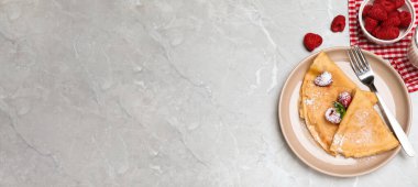 Nane, ahududu ve pudra şekerle servis edilen leziz krepler gri masaya konur, düz yerde yazı için yer vardır. Pankart tasarımı