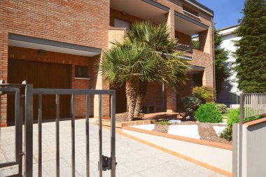Güneşli bir günde bahçesinde güzel palmiye ağaçları olan modern bir apartman.
