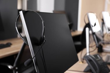 Ofisinde kulaklığı olan modern bir bilgisayar. Yardım hattı servisi