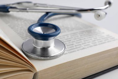 Steteskopla öğrenci ders kitabını aç ve kapat. Tıp eğitimi
