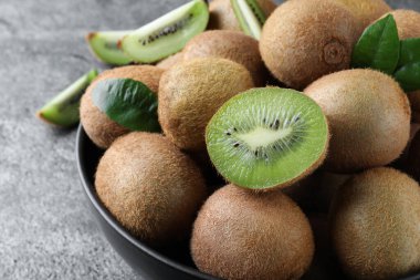 Taze olgun kiviler kasede Gri masada, yakın plan