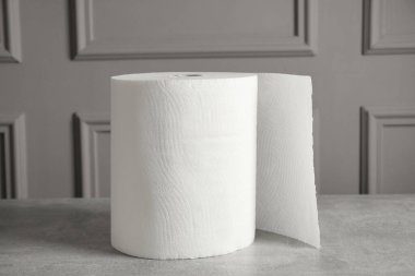 Gri masa üzerinde beyaz kağıt havlu rulosu