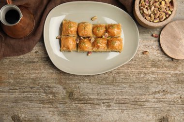Fıstıklı enfes baklava ve ahşap masada sıcak kahve. Metin için boşluk