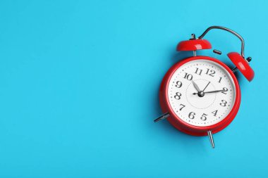 Açık mavi arkaplan üzerindeki alarm saati, metin için alanı olan üst görünüm. Okul zamanı.