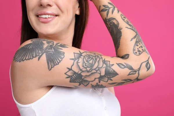 Vacker Kvinna Med Tatueringar Armen Mot Rosa Bakgrund Närbild — Stockfoto
