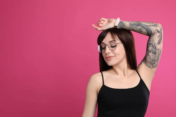 ピンクを背景に腕にタトゥーのある女性 テキストのスペース — ストック写真