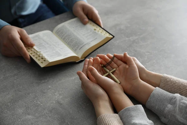 Ragazzo Che Prega Legge Bibbia Con Suoi Padrini Tavola Grigia — Foto Stock