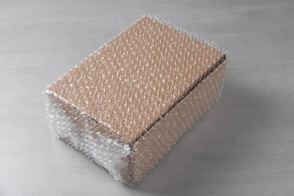 Boîte Carton Recouverte Une Enveloppe Bulles Sur Une Table Gris — Photo