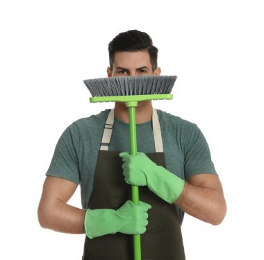 Beyaz arka planda yeşil süpürgesi olan adam.