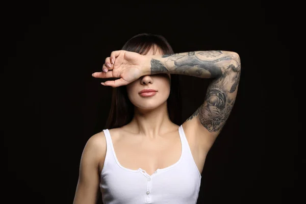 Vacker Kvinna Med Tatueringar Armen Mot Svart Bakgrund — Stockfoto