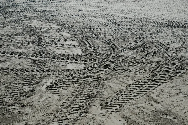 View of vehicle tire marks on sand