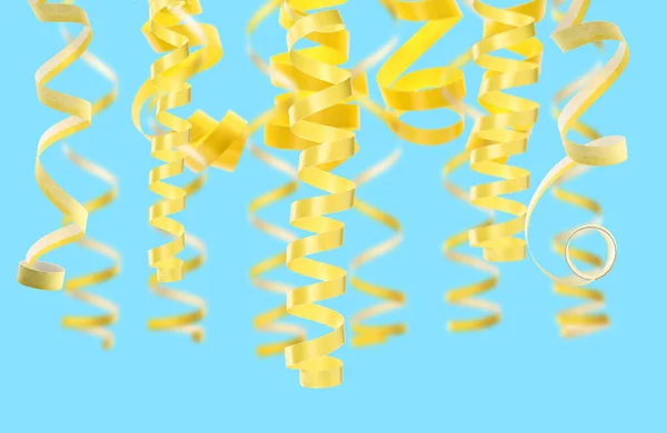 薄い青の背景に多くの黄色の蛇紋岩ストリーマー パーティーの装飾 — ストック写真
