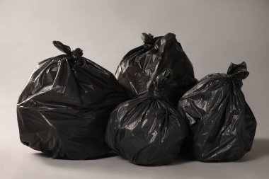 Trash bags full of garbage on grey background