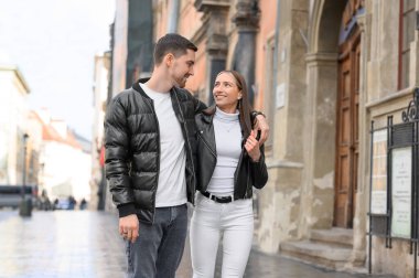 Lovely young couple walking together on city street. Romantic date