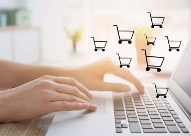 Bilgisayarı ahşap masada online alışveriş için kullanan kadın, yakın plan.