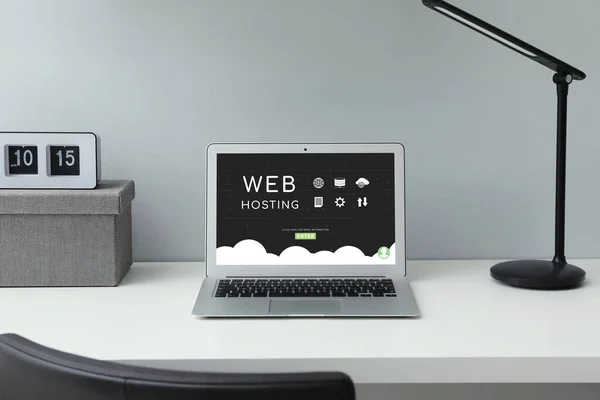 Web hosting service. Comfortable workplace with modern laptop on white table