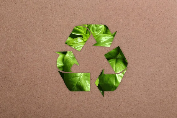 クラフト紙に緑の葉で作られたリサイクルシンボル — ストック写真
