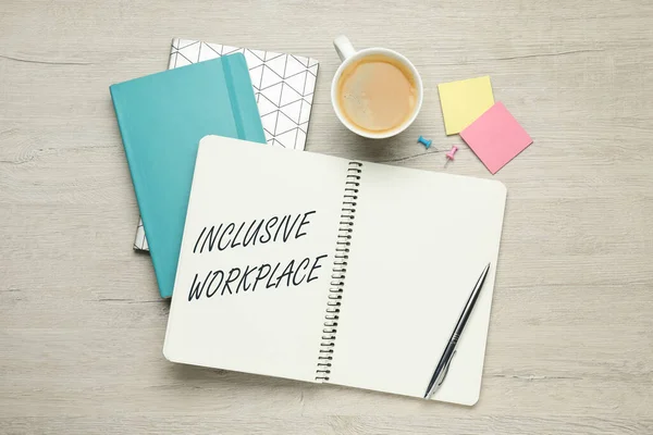 Inclusive workplace. Notebooks, cup of coffee and office stationery on white wooden table, flat lay