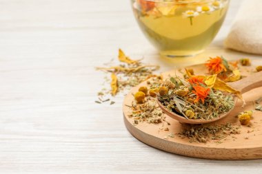 Beyaz ahşap masada kurutulmuş bitki ve çay karışımı. Metin için boşluk