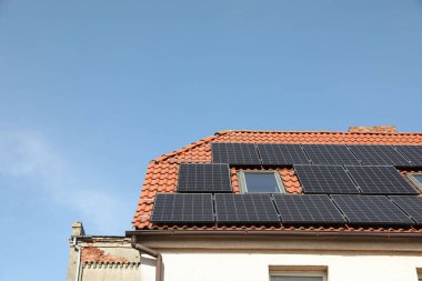 Çatıda güneş panelleri olan bir ev, mesaj için yer. Alternatif enerji