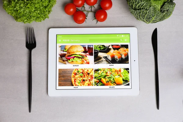 Nowoczesna Tabletka Otwartą Stroną Zamawiania Potraw Online Warzywa Sztućce Szarym — Zdjęcie stockowe