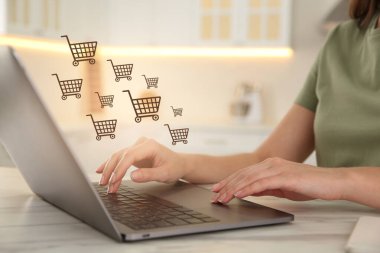 Beyaz mermer masada online alışveriş için dizüstü bilgisayar kullanan kadın, yakın plan.