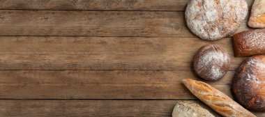 Tahta masadaki farklı taze ekmekler. Düz ve metin için yeri var. Pankart tasarımı