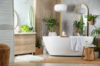 Modern beyaz küvet ve güzel yeşil bitkiler banyoda. İç tasarım