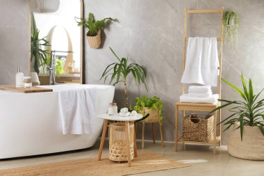 Modern beyaz küvet ve güzel yeşil bitkiler banyoda. İç tasarım