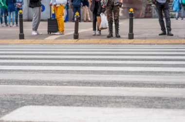 Şehirdeki insanlar karşıdan karşıya geçmek için bekliyor.