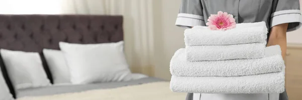 酒店客房里有一堆堆新鲜毛巾的侍女 特写镜头里有文字空间 条幅设计 — 图库照片