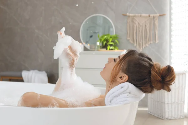 Женщина Наслаждается Ванной Мыльными Пузырями Дома — стоковое фото
