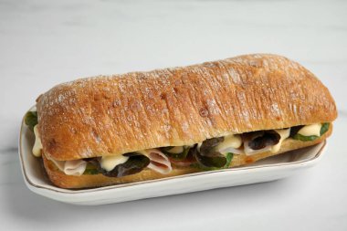 Beyaz masada jambonlu ve mayonezli lezzetli bir sandviç.