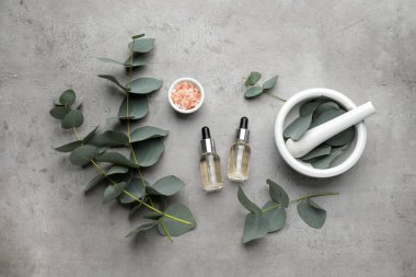 Gri zemin üzerinde okaliptüs şişeleri ile düz bileşim yatıyordu