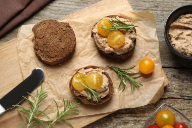 Lezzetli ezmeli, domatesli ve biberiyeli dilimler ahşap masada, düz yatıyordu.