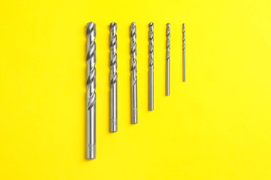 Sarı zemin üzerinde farklı matkap uçları, düz yatıyordu