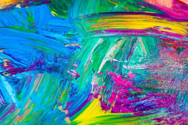 Arkaplan olarak karışık parlak boya içeren ressamın paletinin yakın görüntüsü