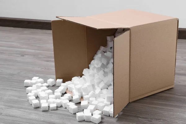 Caja Cartón Volcado Con Cubos Espuma Poliestireno Suelo Madera Interiores —  Fotos de Stock