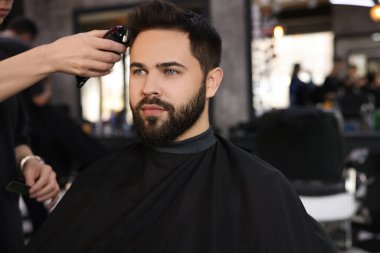 Berber dükkanında müşteriyle çalışan profesyonel kuaför.