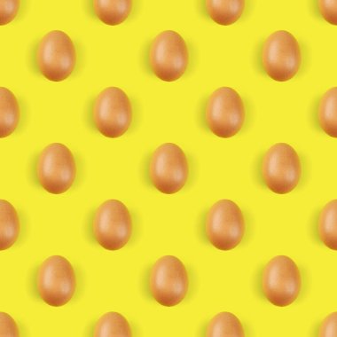 Sarı arka planda bir grup tavuk yumurtası. Kusursuz desen tasarımı