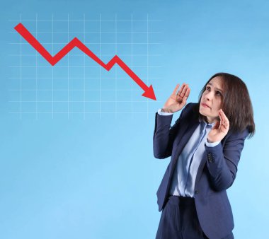 Endişeli iş kadını ve açık mavi arka planda düşüşün çizelgesi. Ekonomik durgunluk