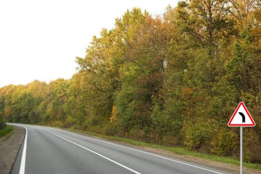 Trafik levhası Sonbaharda boş asfalt yolunun yakınından ayrıldı