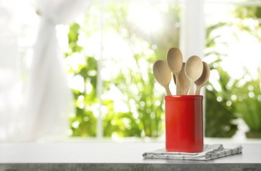 Katlanmış mutfak havlusu ve içinde kaşık olan gri masa, mesaj için yer var. Bokeh etkisi