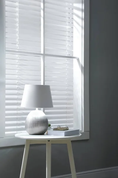 Room interior with stylish lamp on table